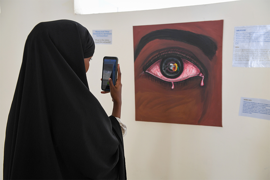 Somalia woman taking photo of museum artwork 
