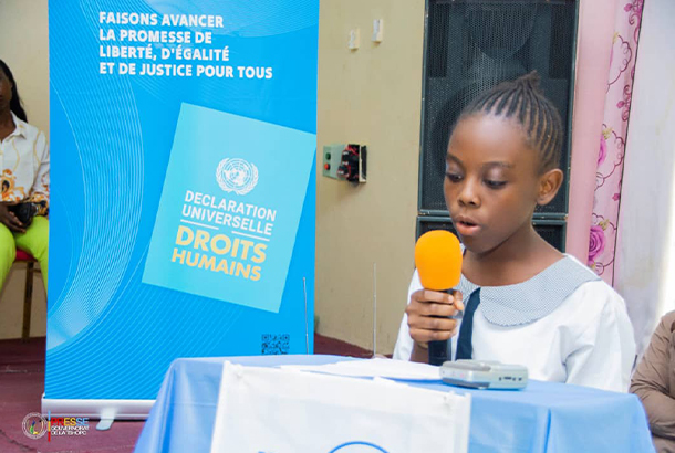A young girl reading the UDHR