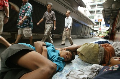 Homeless children sleep on a sidewalk in Bangkok. © Credit – EPA/ Vinai Dithajohnn