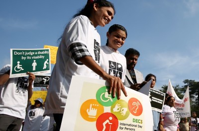 Personas con discapacidades sostienen pancartas durante el Día Internacional de las Personas con Discapacidad en Bangalore, India. © EPA