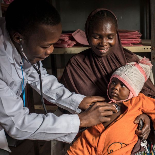 A health worker examines a young boy in a health clinic, northeastern Nigeria. © UNICEF/UNI279436/Modola