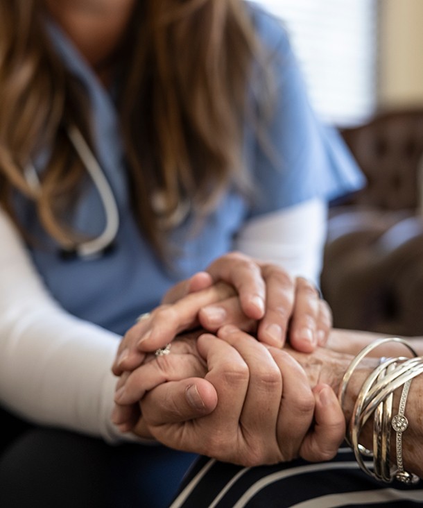 A caregiver holding a person's hand
