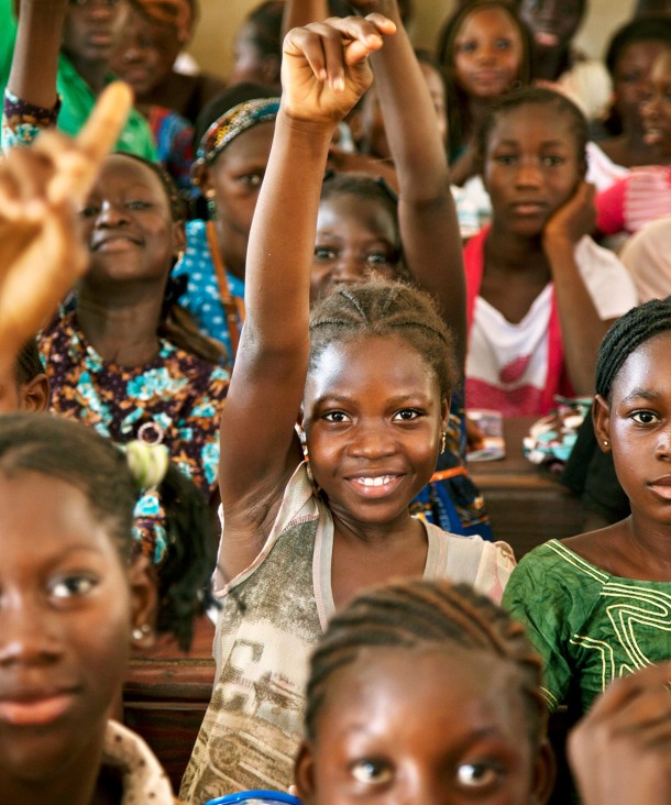 Schoolgirl raising hand in classroom 