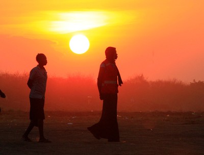 People who fled fighting in South Sudan are seen walking at sunset on arrival at a refugee camp.© REUTERS/James Akena