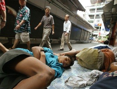 Homeless children sleep on a sidewalk in Bangkok. © Credit – EPA/ Vinai Dithajohnn