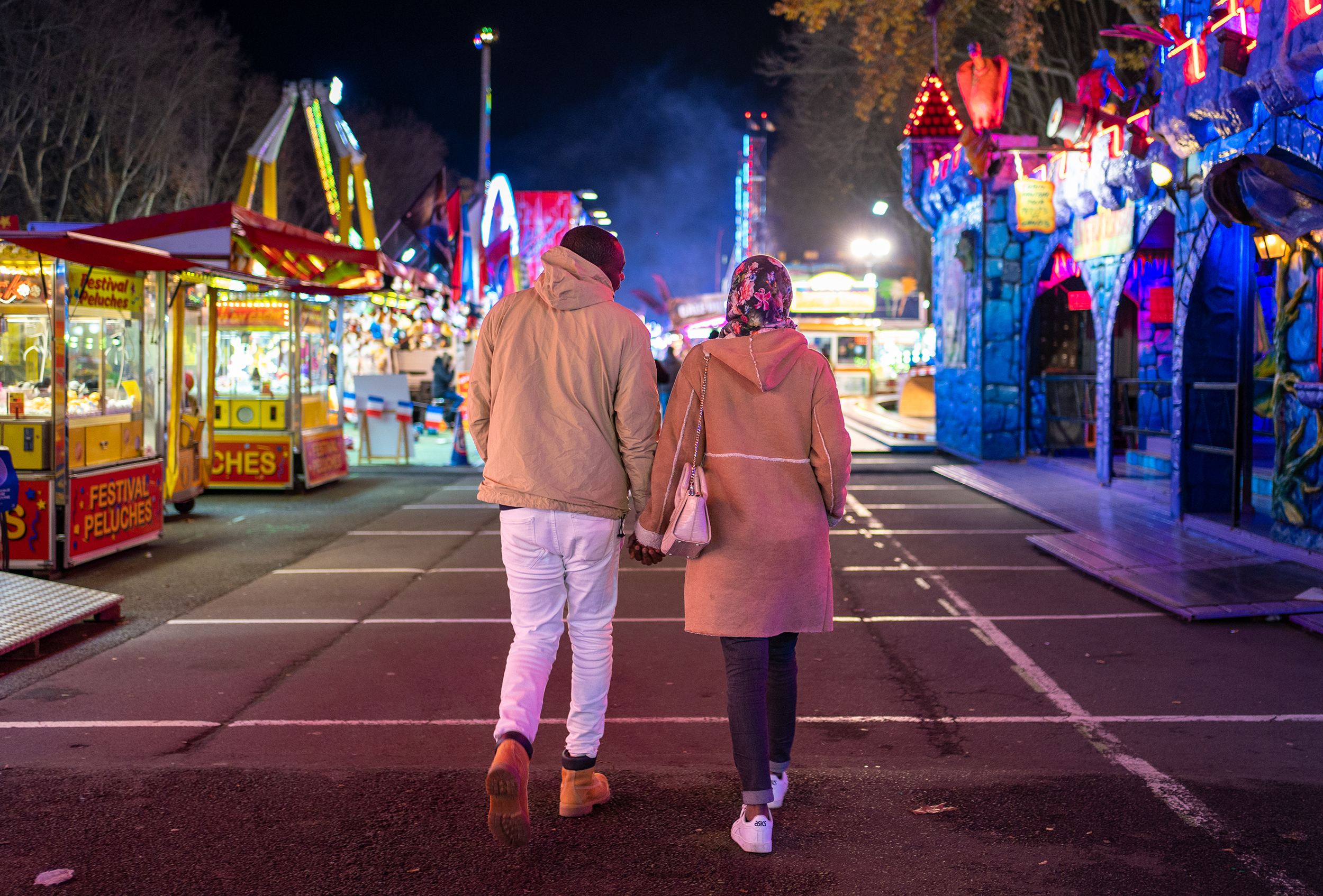 Moussa and his girlfriend Lina walk hand in hand at the Christmas Fair in Angers, France
