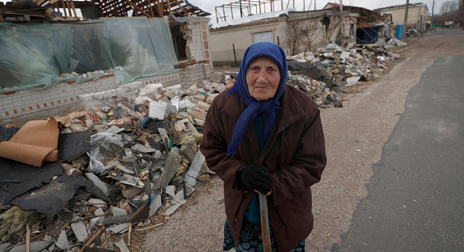 90-летняя Ладан Евдокимовна идет мимо своего дома, разрушенного после авиаудара российских сил в поселении в Киевской области, 29 марта 2022 г. EPA-EFE/ATEF SAFADI