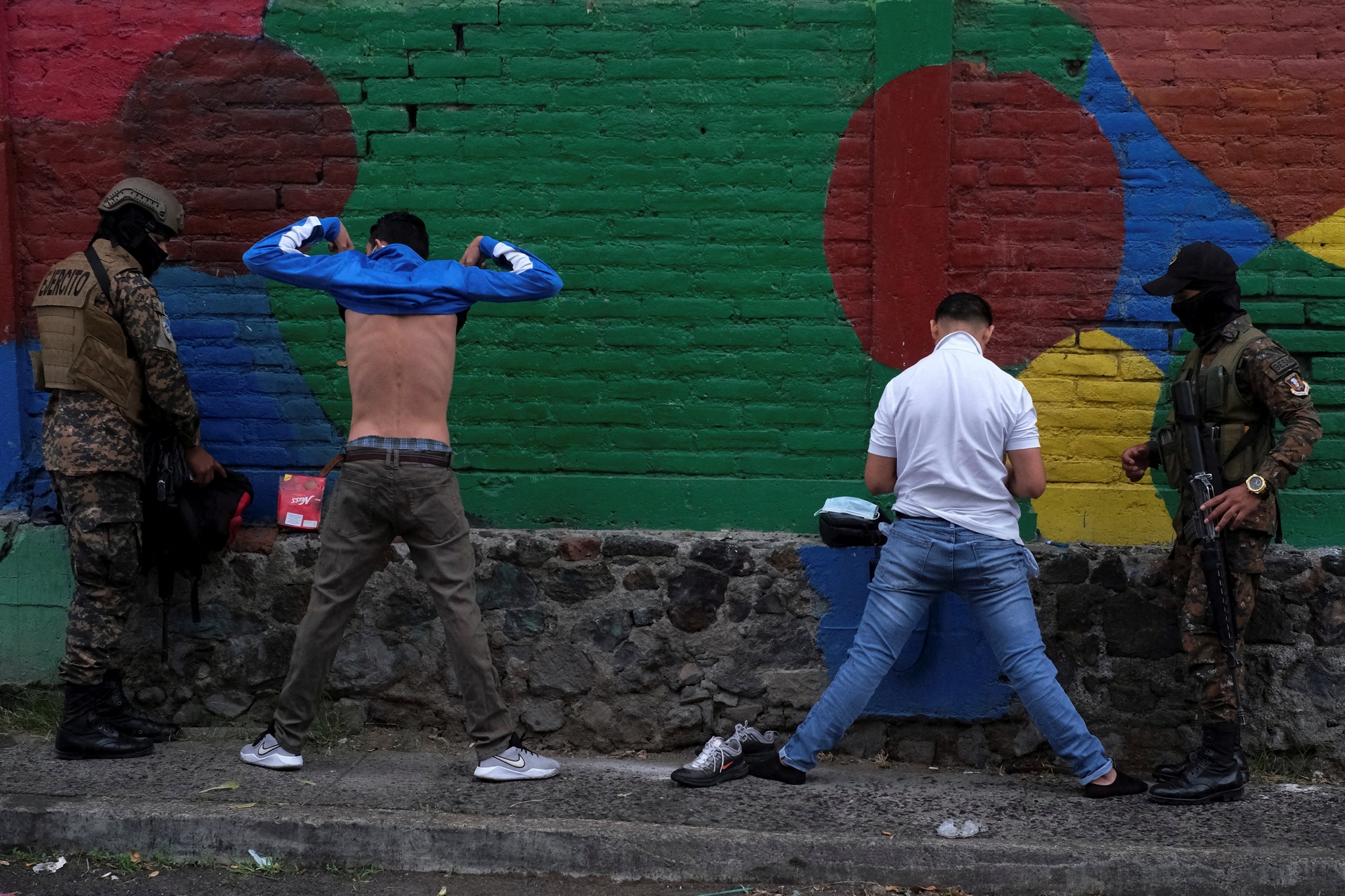 Soldiers search men at a checkpoint in the Iberia neighborhood after El Salvador's Congress approved on Sunday emergency powers that temporarily suspended some constitutional protections after the country recorded a sharp rise in killings attributed to criminal gangs, in San Salvador, El Salvador, March 30, 2022 © REUTERS/Jose Cabezas