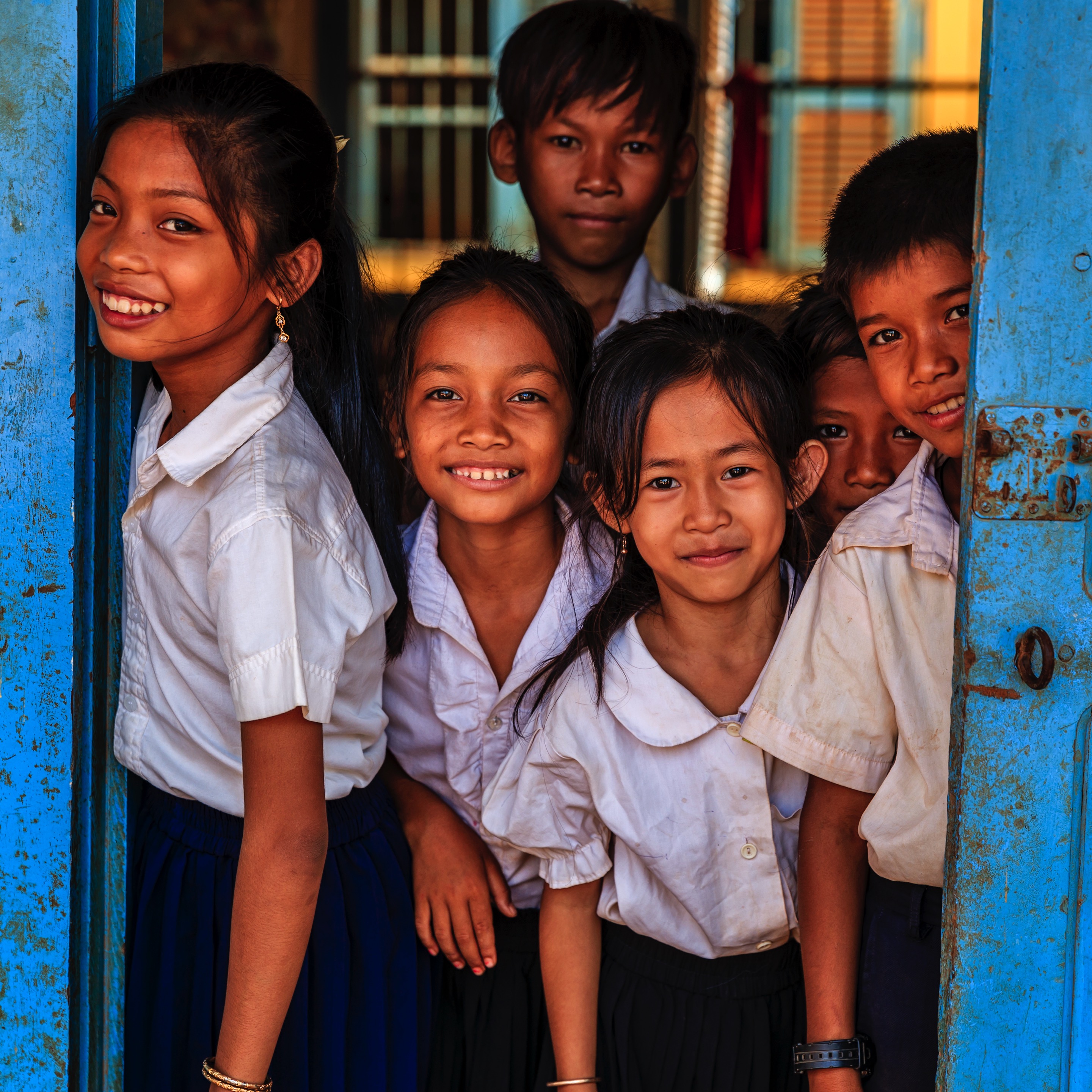 Cambodian school children standing in doorway of classroom in small village near Tonle Sap, Cambodia © Getty Images