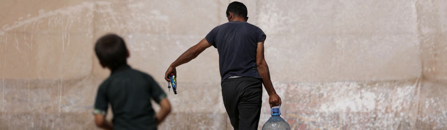 A man carries a water container as he walks past a tent in a camp for internally displaced Syrians, in northern rebel-held Idlib, Syria September 25, 2022. © Reuters