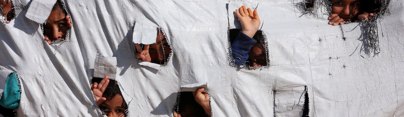 Children look through holes in a tent at al-Hol displacement camp in Hasaka governorate, Syria, April 2, 2019.© Reuters