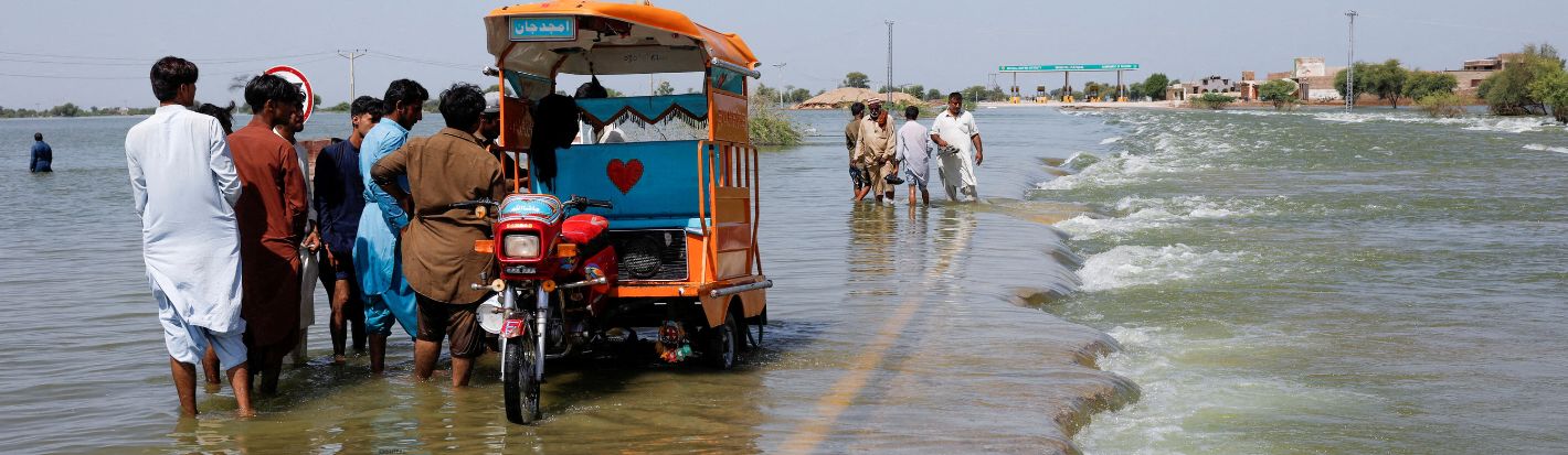 مشرّدون يقفون على طريق سريع غمرته المياه بعد الأمطار والفيضانات خلال موسم الرياح الموسمية في سهوان بباكستان، 16 أيلول/ سبتمبر 2022. © رويترز