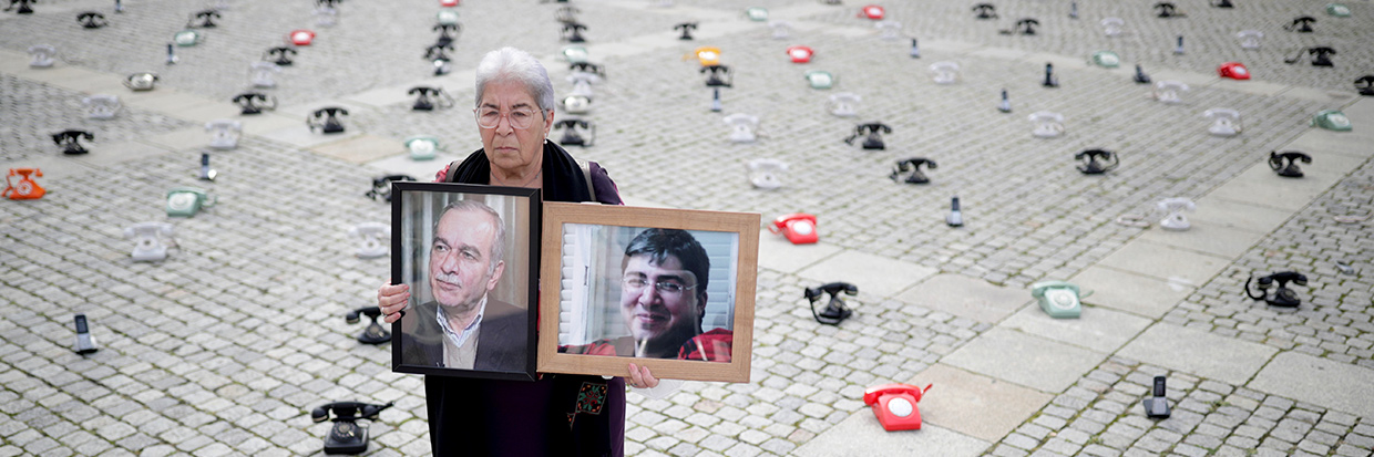 2022年1月，一名叙利亚情报官员在德国科布伦茨地方法院受审，法德瓦·马哈茂德（Fadwa Mahmoud）在法院外举着丈夫和儿子的照片，他们于2012年失踪。© Thomas Frey／Pool via REUTERS