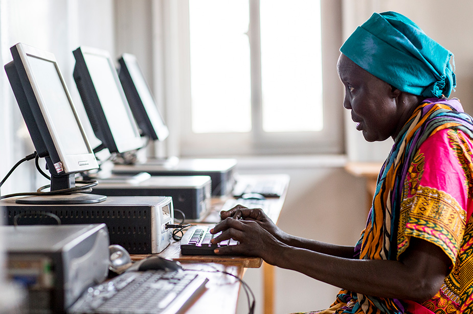A woman living at a Protection of Civilian site (PoC) in Juba, South Sudan learns computer skills. More women and girls need to learn and create technology to help bridge the digital gender divide. © UN Photo/JC McIlwaine