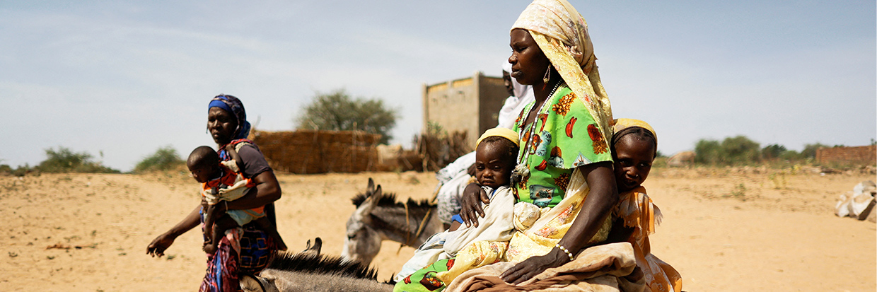 2023年5月8日，一名从苏丹达尔富尔地区的暴力中逃离的苏丹难民妇女哈瓦·亚当（Hawa Adam）正和孩子一起骑着毛驴前往苏丹和乍得边境的贡古尔附近的供水点。Ⓒ路透社/Zohra Bensemr