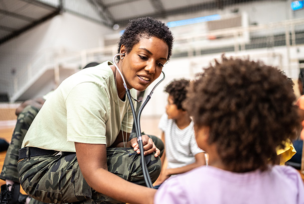 Un médico del ejército examina a niños refugiados en un centro comunitario.