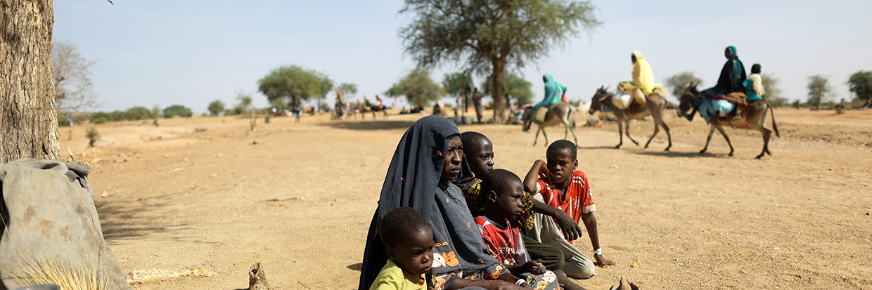 2023年5月8日，逃离苏丹达尔富尔地区暴力冲突的苏丹难民妇女哈利玛·雅库布（Halime Yakoub）在与记者们进行交谈，她和她的孩子们坐在临时避难所旁。这处临时避难所是在苏丹和乍得边境附近的贡古尔（Goungour）。©路透社／Zohra Bensemra
