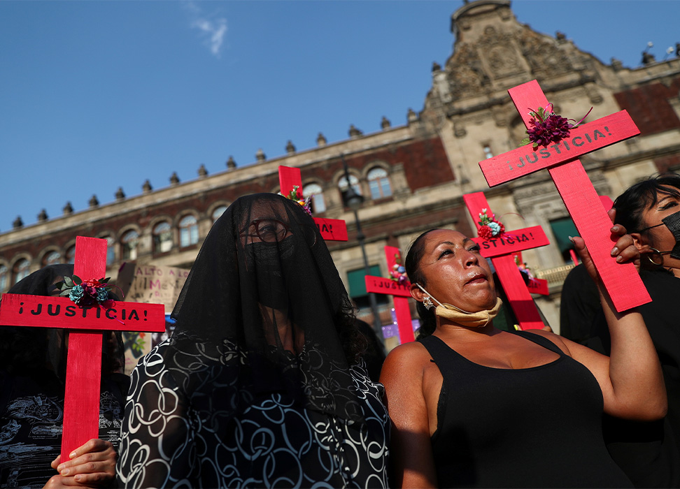 Women hold crosses in a protest against femicide and violence against women outside the National Palace in Mexico City, Mexico. © REUTERS/Edgard Garrido.