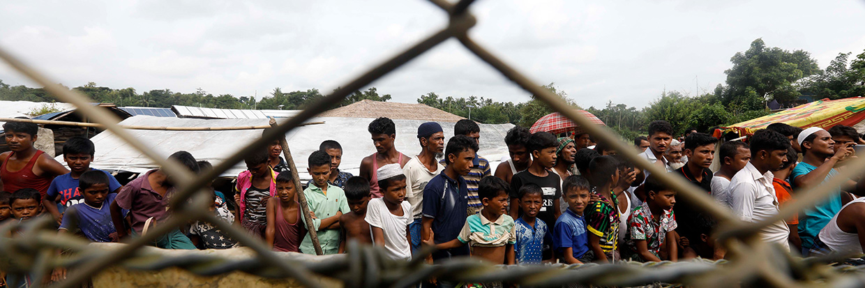 2018年8月24日，缅甸西部若开邦孟都区，罗兴亚难民聚集在缅甸和孟加拉国边境的“无人区”围栏附近。图片来源：欧新社-埃菲通讯社/NYEIN CHAN NAING