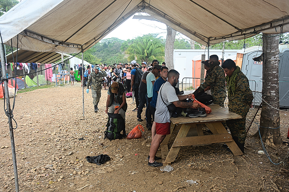 Newly arrived migrants having bags searched and are registered by agents from the National Border Service at the intake centre. © Carlos Rodriguez/ROCA 
