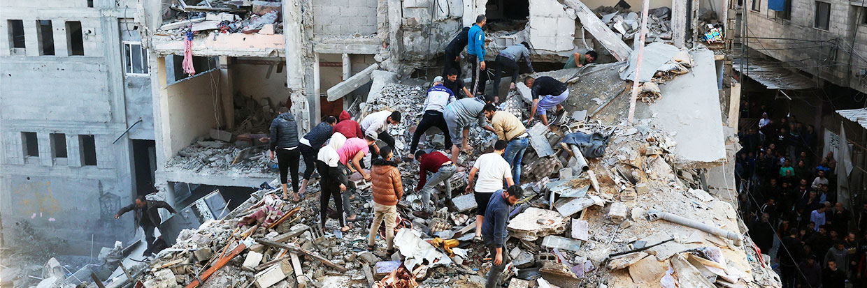 Des Palestiniens mesurent l’ampleur des destructions autour des bâtiments résidentiels à la suite de frappes aériennes israéliennes dans le camp de réfugiés de Rafah, dans le sud de la bande de Gaza, le 1er décembre 2023, alors que les combats ont repris peu après l’expiration d’une trêve de sept jours entre Israël et les militants du Hamas. © SAID KHATIB/AFP