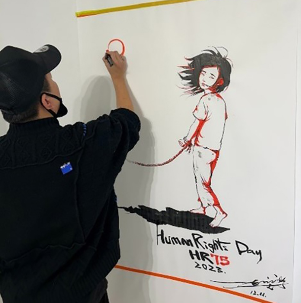Mr. Chun-hyok Kang, an artist from DPRK, conducting a live painting at the exhibition. © OHCHR
