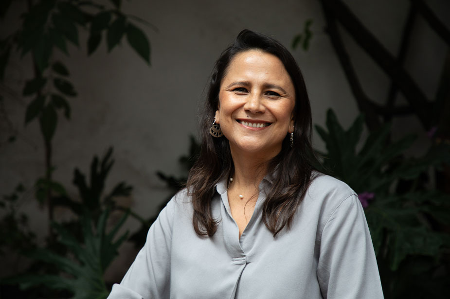 A woman smiles looking at the camera. 