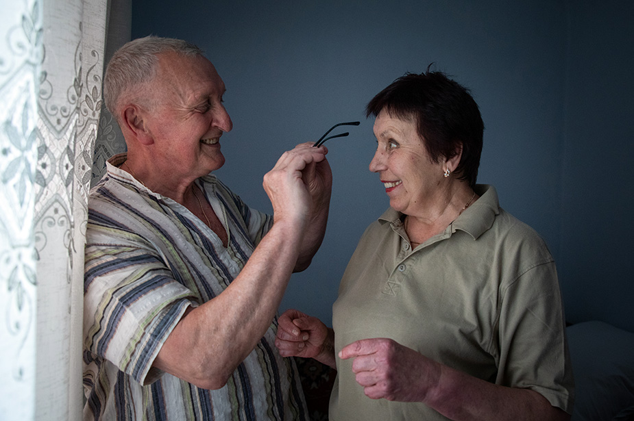 Oleksandr, who uses a hearing aid, puts a pair of glasses on his wife, Olga.