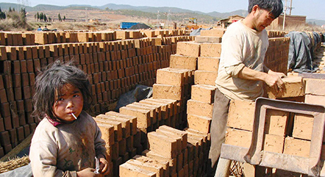 A child works with his father at a brick factory. © EPA/Wang Bingyu