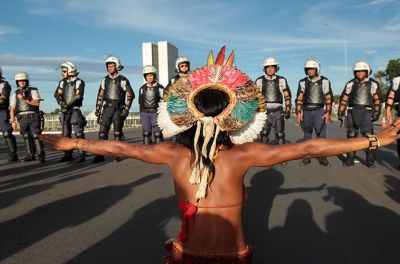 巴西巴西利亚一场维护土地权抗议活动中，一名土著人在执法官员面前举起双臂以示抗议。©Joédson Alves/欧洲新闻图片社﻿