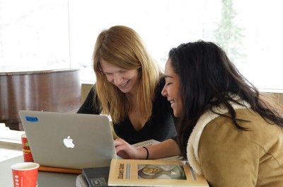 Two women looking at a laptop, smiling. ©Wikimedia