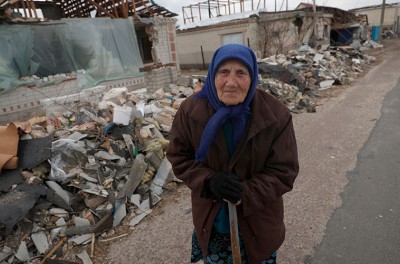 لادان إفدوكيميفنا البالغة من العمر 90 عامًا، تمشي بجوار أنقاض منزلها في أعقاب غارة جوية روسية ضربت قرية أوليكا سزكولنا في إقليم كييف، في 29 آذار/ مارس 2022. الوكالة الأوروبية للصور الصحفية/ عاطف صفدي