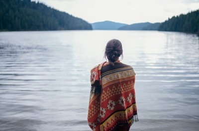 Woman standing in front of mountain lake 