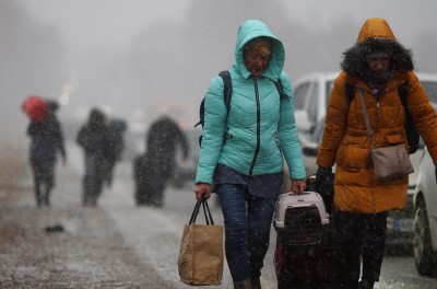 Des réfugiés originaires d’Ukraine marchent péniblement en direction de la frontière polonaise. REUTERS/Thomas Peter