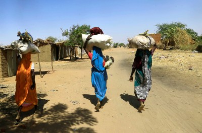 Internally displaced Sudanese women carry bags of farm products on their heads as they walk within the Kalma camp for internally displaced persons (IDPs) in Darfur, Sudan April 25, 2019