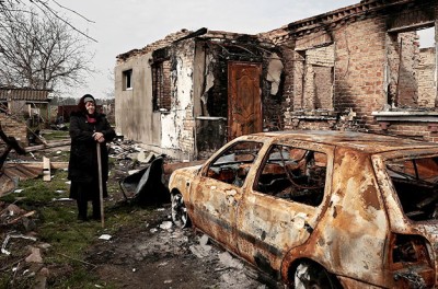 لودميلا سادلوفا البالغة من العمر 72 عامًا، تقف أمام منزلها، الذي قالت إن الصواريخ أصابته في 12 أذار/ مارس، في سياق الغزو الروسي لأوكرانيا، في أوزيرا بمنطقة كييف في أوكرانيا، في 23 نيسان/ أبريل 2022.