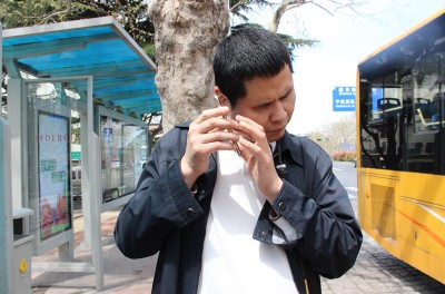2019年11月5日，在中国东部的山东省青岛市，一名盲人使用一款手机应用程序帮助自己乘坐公交车。