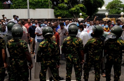 Manifestantes progubernamentales en Sri Lanka destruyen tiendas de manifestantes contra el gobierno a los que llaman ' Mainagogama' mientras agentes de policía observan frente a los árboles de los templos, Colombo, Sri Lanka.       9 de mayo de 2022 (Foto de Tharaka Basnayaka/NurPhoto)