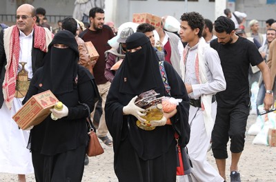 People carry food items they received from the local charity, Mona Relief, in Sanaa, Yemen April 24, 2022. © REUTERS/Khaled Abdullah