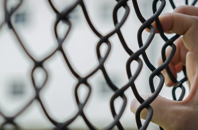 Hand holding wire mesh cage. © Getty Images