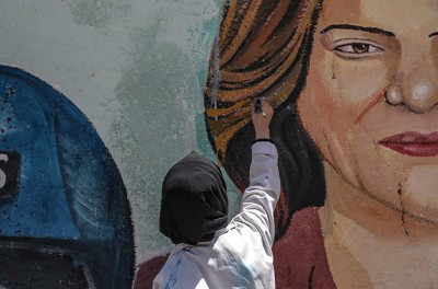 فنانة فلسطينية ترسم جدارية لصحفية الجزيرة شيرين أبو عاقلة في مدينة غزة، 12 أيار/ مايو 2022. © الوكالة الأوروبية للصور الصحفية - وكالة الإعلام الإسبانيّة