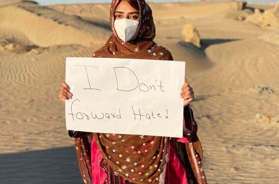 A girl carrying a sign "I Don’t Forward Hate"