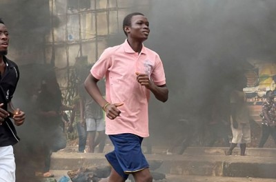 Des personnes s'enfuient pendant une manifestation anti-gouvernementale, à Freetown, en Sierra Leone, le 10 août 2022