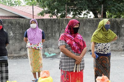 Rohingya refugees wearing protective masks keep a social distance while waiting to receive goods from volunteers, during the movement control order due to the outbreak of the coronavirus disease (COVID-19), in Kuala Lumpur, Malaysia April 7, 2020. REUTERS/Lim Huey Teng/File Photo/File Photo