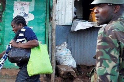 Une femme court devant un policier durant les affrontements entre des partisans de l’opposition et la police dans le quartier insalubre de Kawangware à Nairobi, au Kenya, le 30 octobre 2017. © REUTERS/Goran Tomasevic