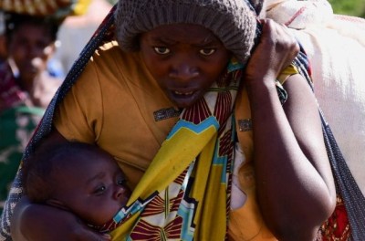 Une civile congolaise porte son enfant et ses affaires personnelles après avoir fui la reprise des combats entre les assaillants et les soldats de la République démocratique du Congo et de l’Ouganda, au point de passage frontalier de Bunagana situé dans l’ouest de l’Ouganda, le 10 novembre 2021.