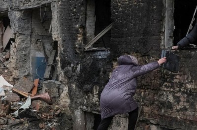 Des habitants récupèrent des affaires dans leur immeuble détruit par une attaque de missiles russes, alors que l’attaque de la Fédération de Russie contre l’Ukraine se poursuit, dans la ville de Vyshhorod, près de Kyïv, le 24 novembre 2022. Ⓒ REUTERS/Gleb Garanich
