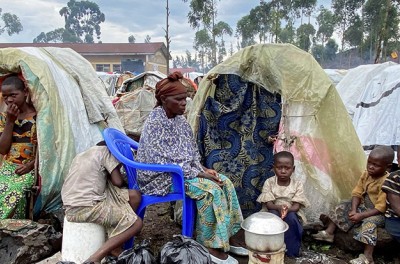 باسكازيا كيمانوكا البالغة من العمر 58 عامًا، تجلس مع أطفالها أمام المأوى المؤقت القائم في مخيم كانياروتشينيا للمشرّدين داخليًا بالقرب من غوما في مقاطعة شمال كيفو بجمهورية الكونغو الديمقراطية في 22 تشرين الثاني/ نوفمبر 2022. © رويترز/ جعفر سابيتي