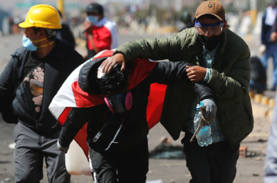 A demonstrator assists an injured man during a clash with security forces, demanding early elections and the release of jailed former President Pedro Castillo, near the Juliaca airport, in Juliaca, Peru January 9, 2023. © REUTERS/Hugo Courotto 