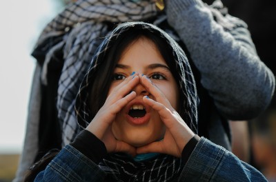 Photo de couverture de l’Appel annuel du HCDH pour 2023. Une jeune fille portant un foulard met ses mains autour de la bouche en criant lors d’une manifestation à Beyrouth, au Liban, le 10 février 2021. © Florient Zwein/Reuters